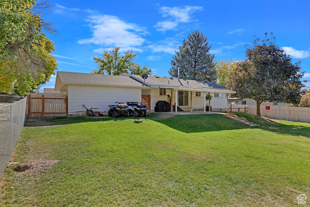 Rear view of house featuring a patio and a yard