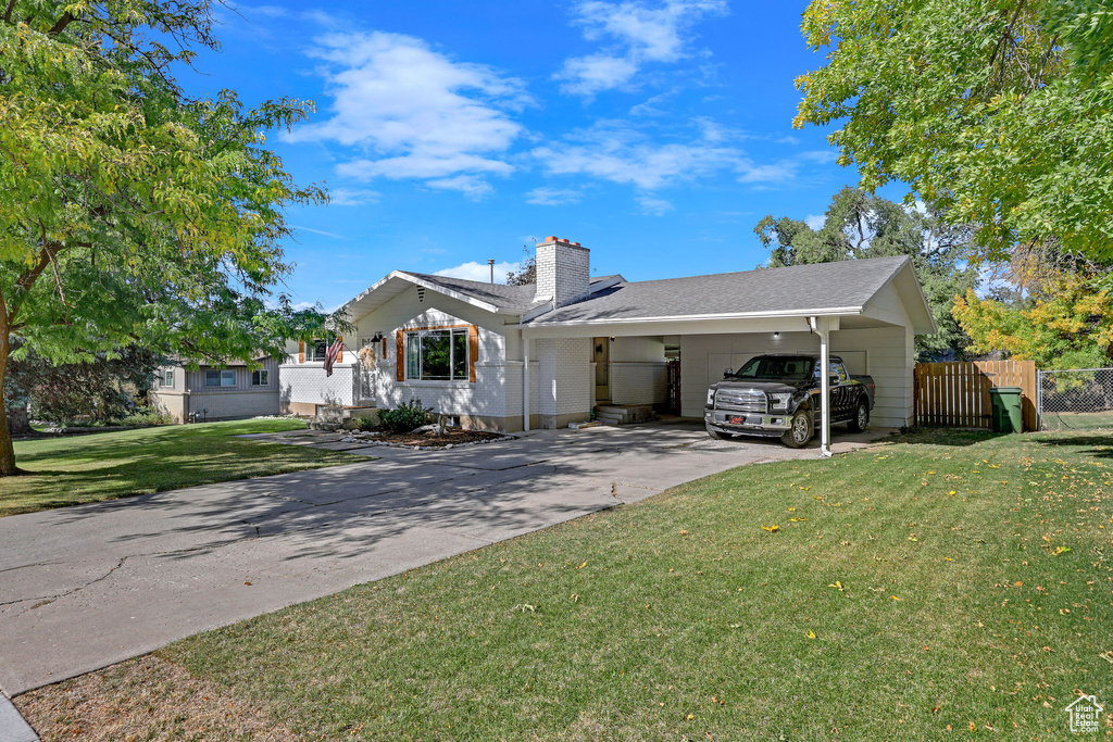 View of front of house featuring a front lawn and a carport