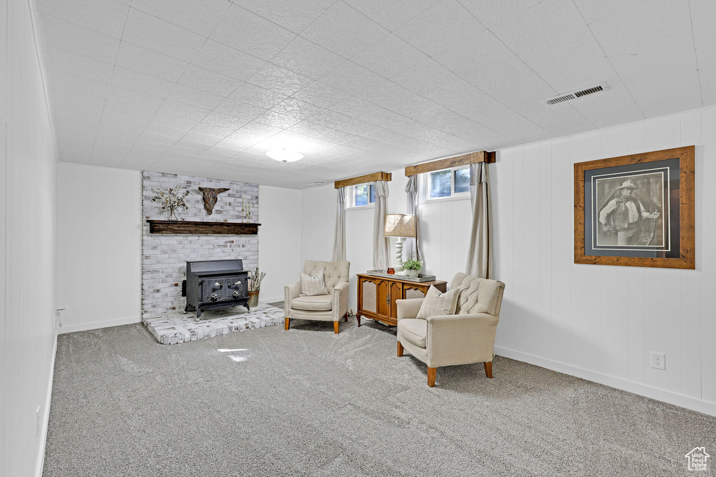 Sitting room featuring a wood stove and carpet floors