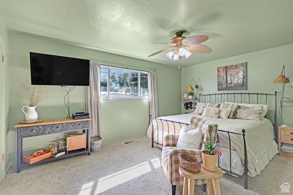 Bedroom featuring a textured ceiling, carpet, and ceiling fan