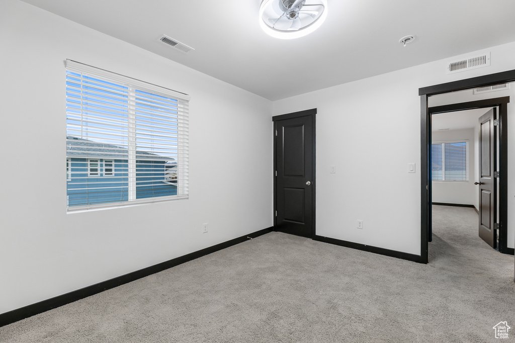 Unfurnished bedroom featuring light carpet