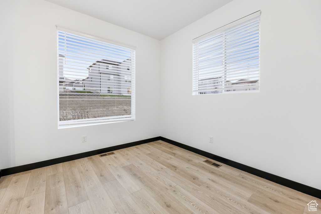 Spare room featuring light hardwood / wood-style flooring and a wealth of natural light