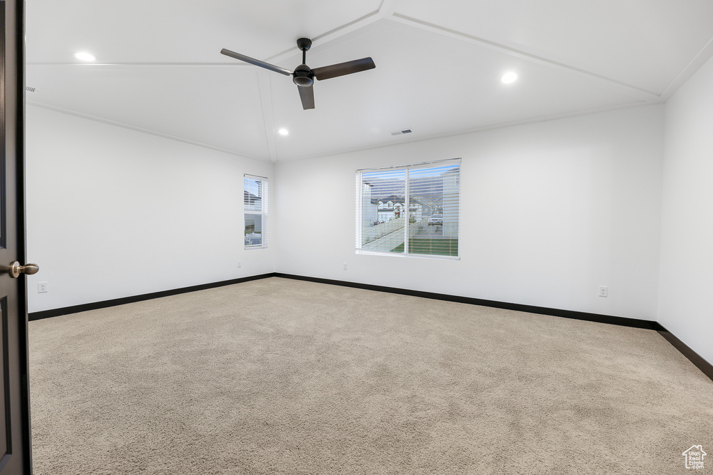 Spare room featuring vaulted ceiling and carpet