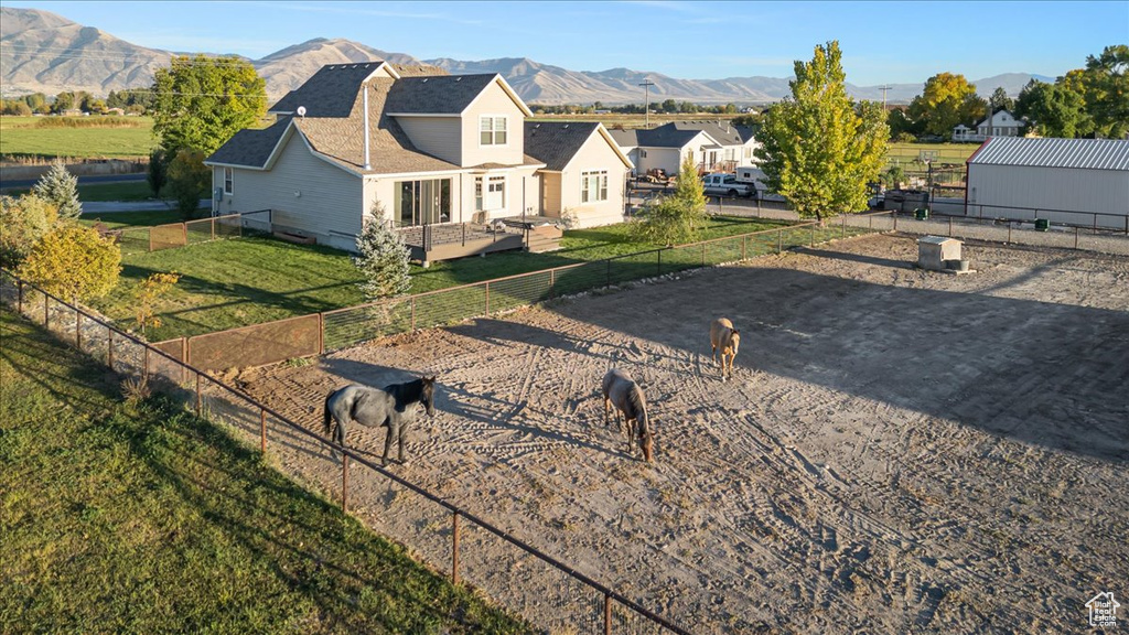 View of front of home with a front yard and a deck with mountain view