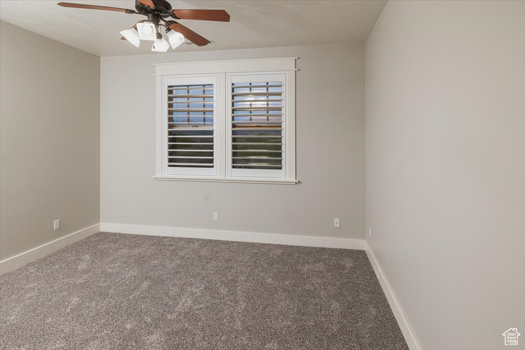 Carpeted empty room with ceiling fan