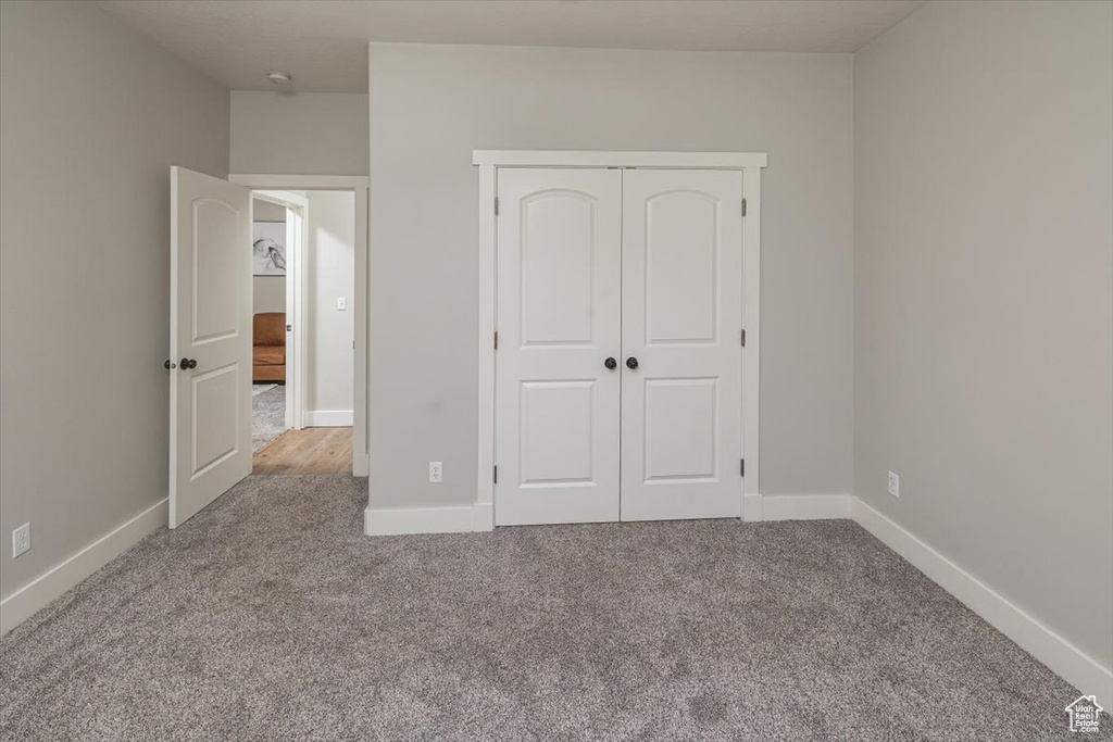 Unfurnished bedroom featuring a closet and carpet floors