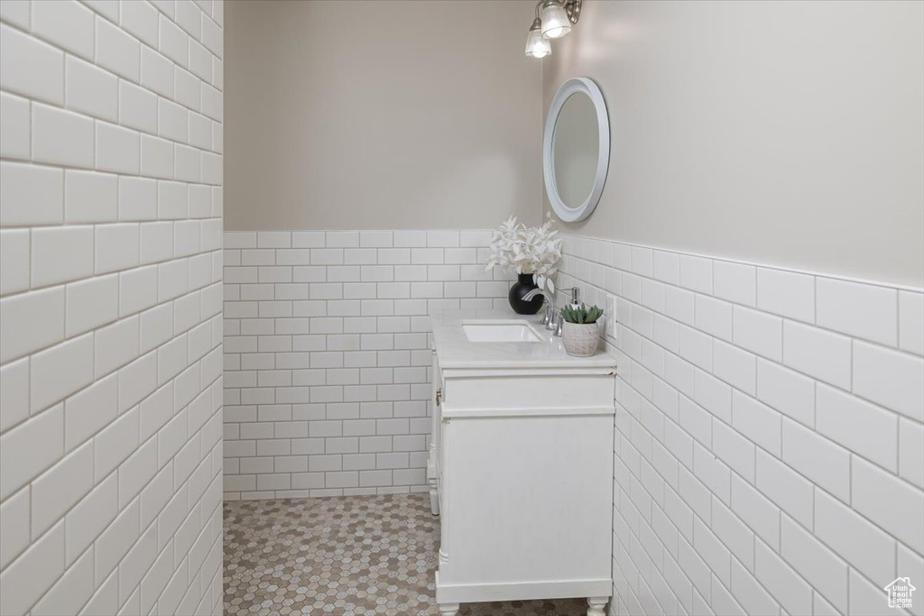 Bathroom with vanity and tile walls