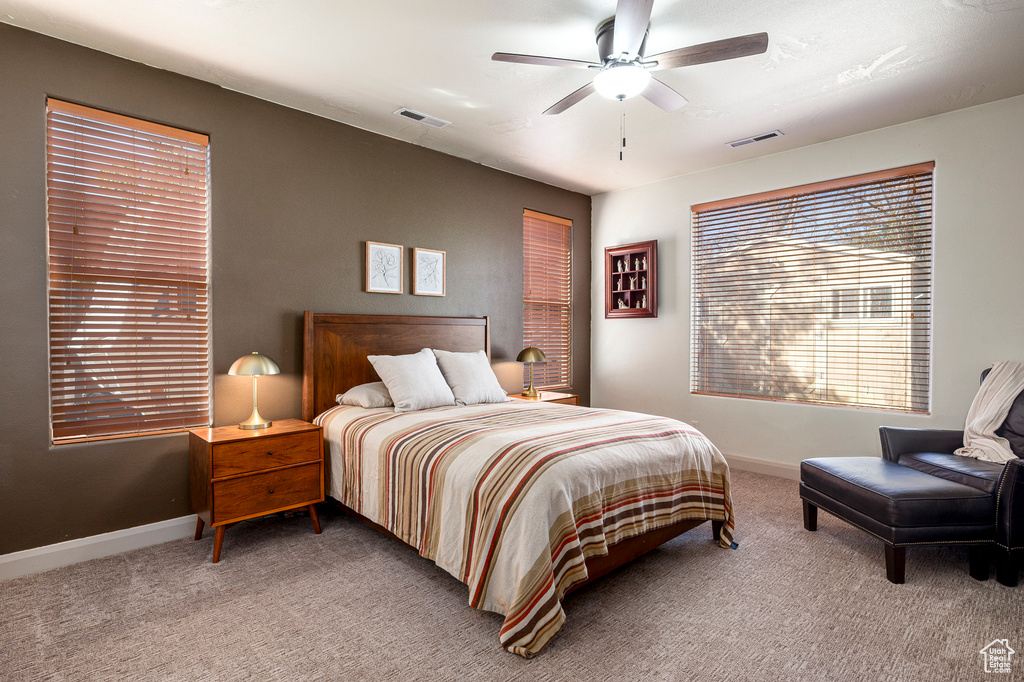 Carpeted bedroom featuring ceiling fan