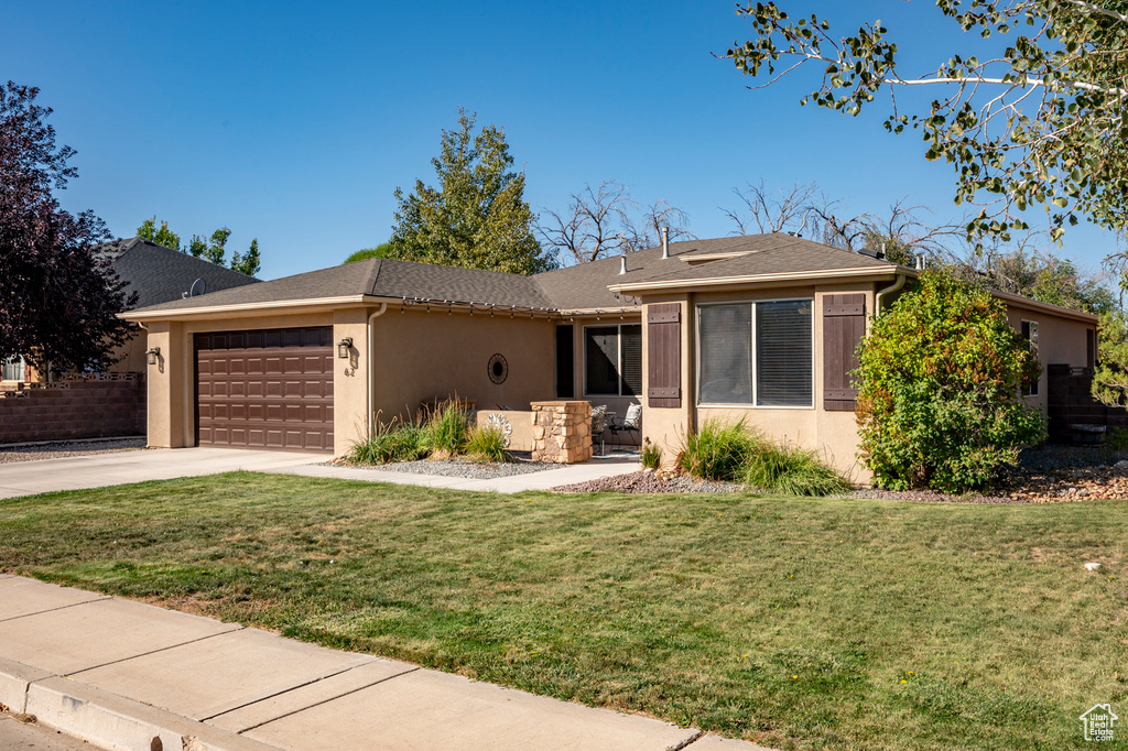 Ranch-style house featuring a garage and a front yard