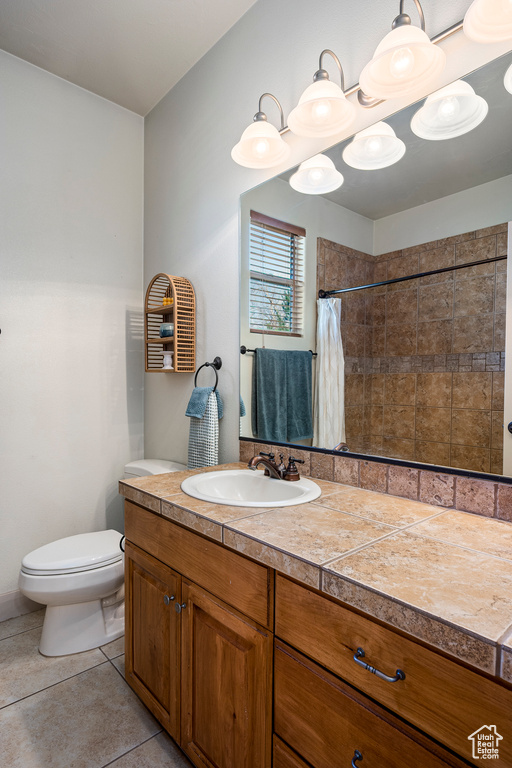 Bathroom with tile patterned floors, a shower with curtain, vanity, and toilet