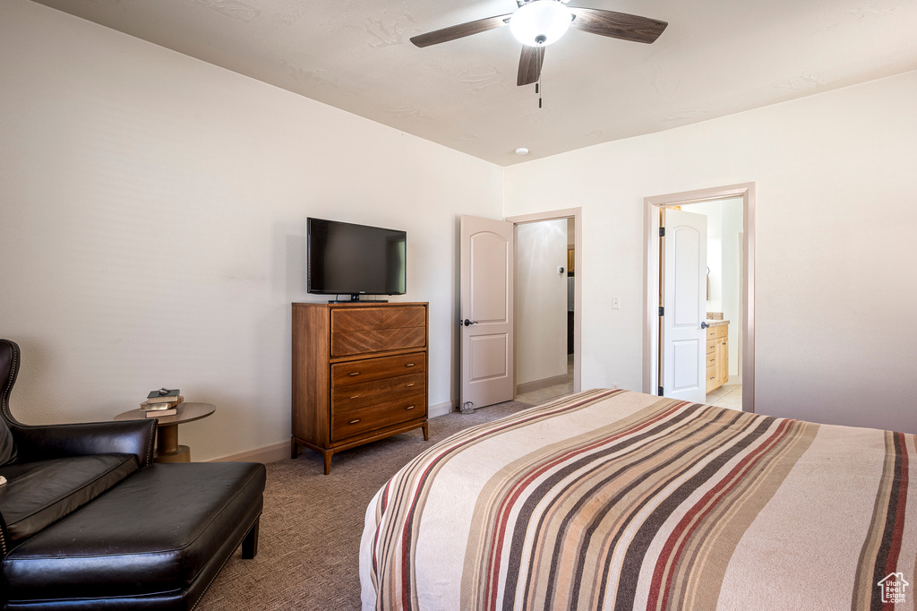 Bedroom featuring ceiling fan, light colored carpet, and connected bathroom