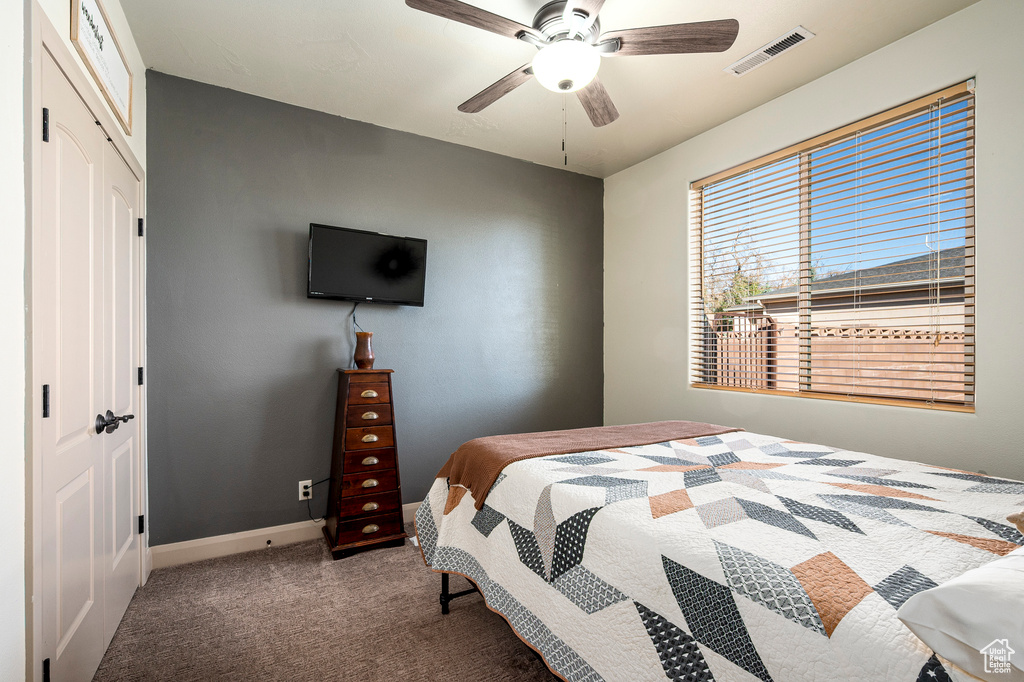 Bedroom with carpet flooring, ceiling fan, and a closet