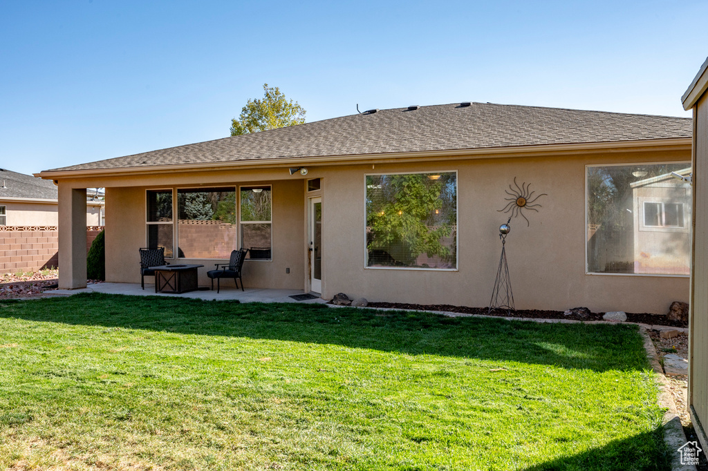 Rear view of house featuring a patio and a yard