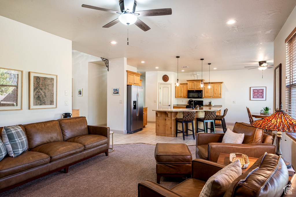 Tiled living room with ceiling fan, a healthy amount of sunlight, and sink