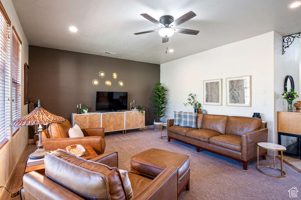 Carpeted living room featuring ceiling fan