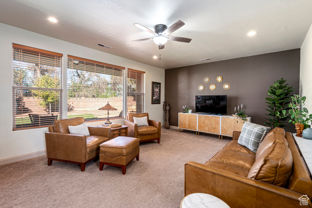 Living room with ceiling fan and light carpet