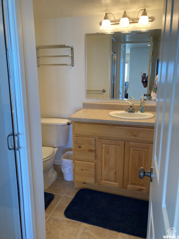 Bathroom with tile patterned flooring, vanity, and toilet