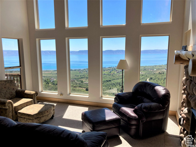 Carpeted living room with a towering ceiling and a mountain view