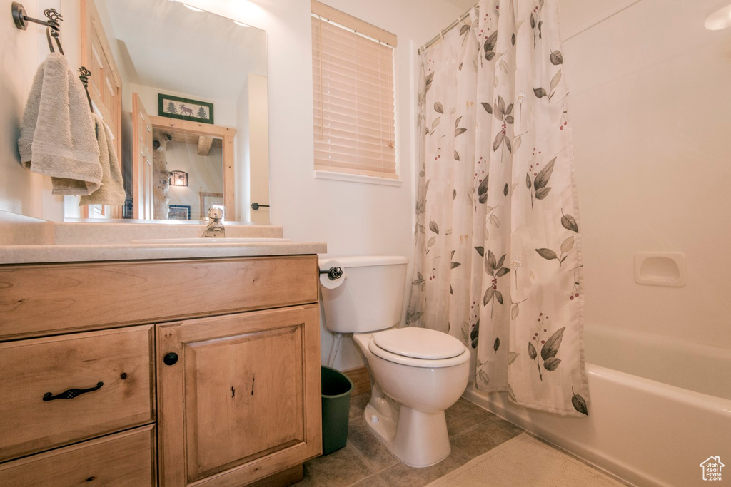 Full bathroom featuring tile patterned floors, shower / bath combo, vanity, and toilet