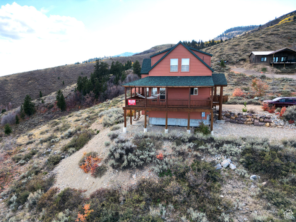 Rear view of property featuring a mountain view, a porch, and a garage