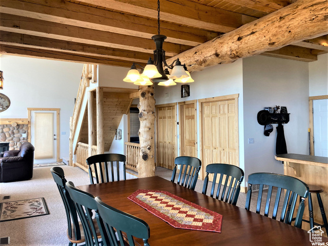 Dining space with an inviting chandelier, beam ceiling, and wooden ceiling