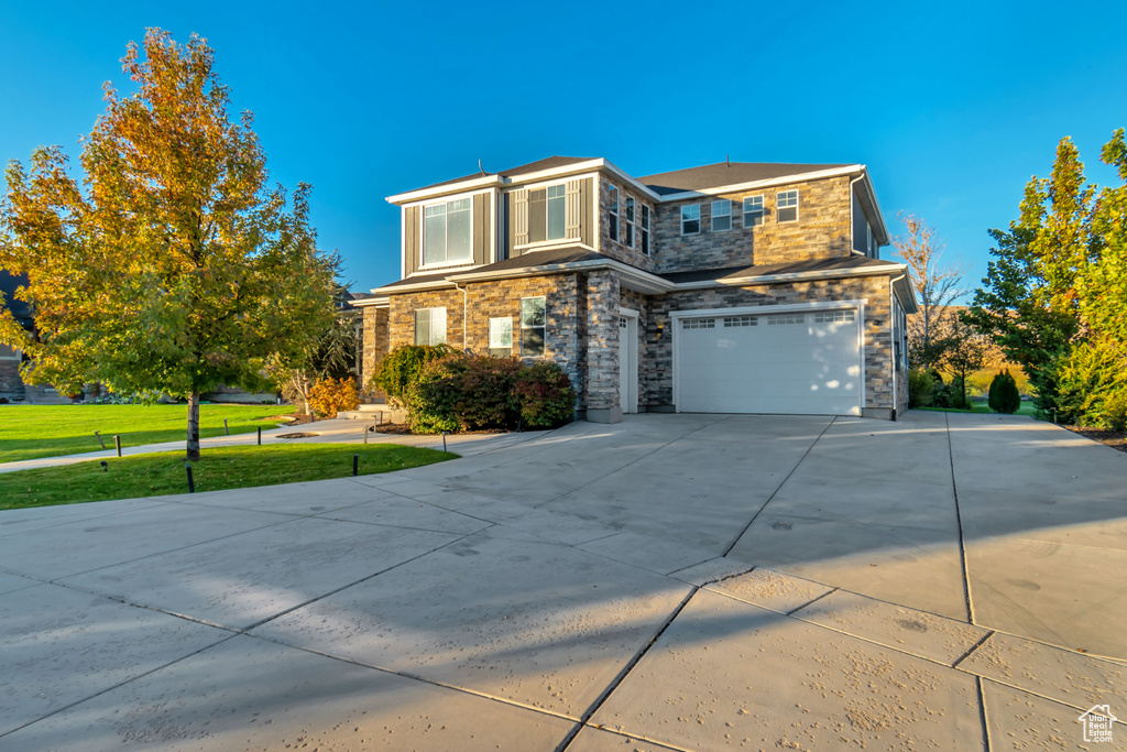 View of front of property featuring a front lawn and a garage