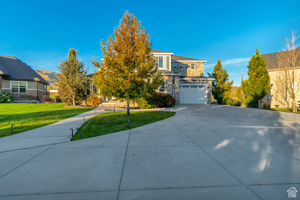 View of front of house featuring a front lawn and a garage