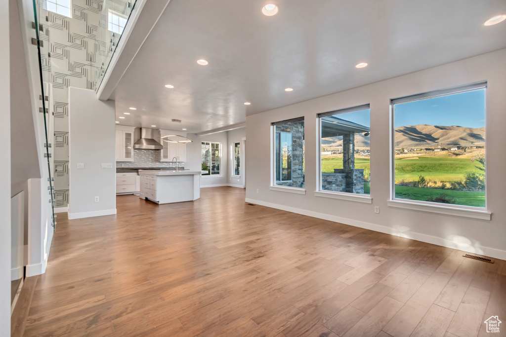 Unfurnished living room with hardwood / wood-style flooring and sink