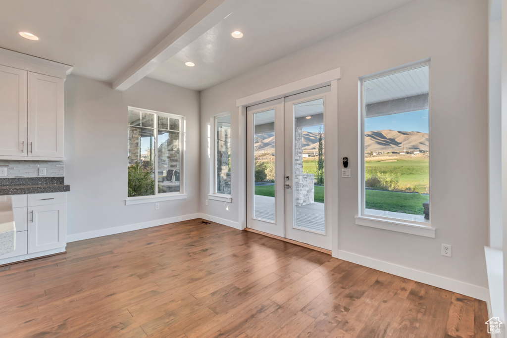 Doorway to outside featuring hardwood / wood-style flooring, beam ceiling, and french doors