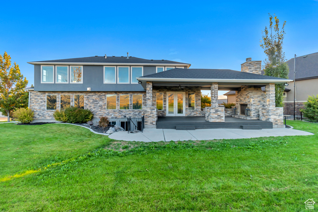 Back of house with a lawn and a patio area