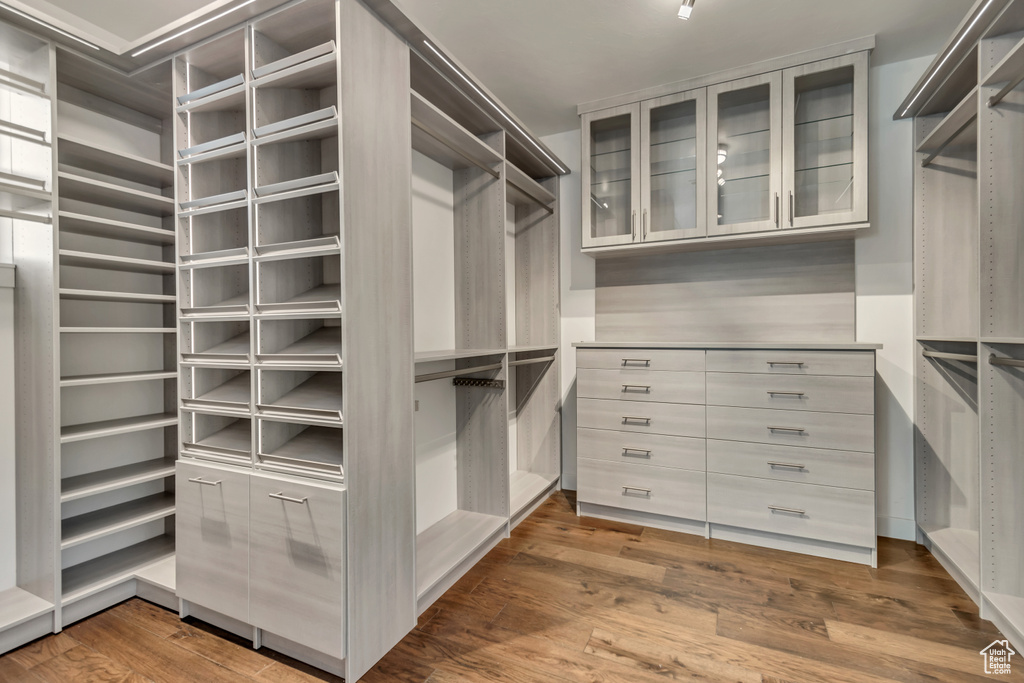 Walk in closet with wood-type flooring