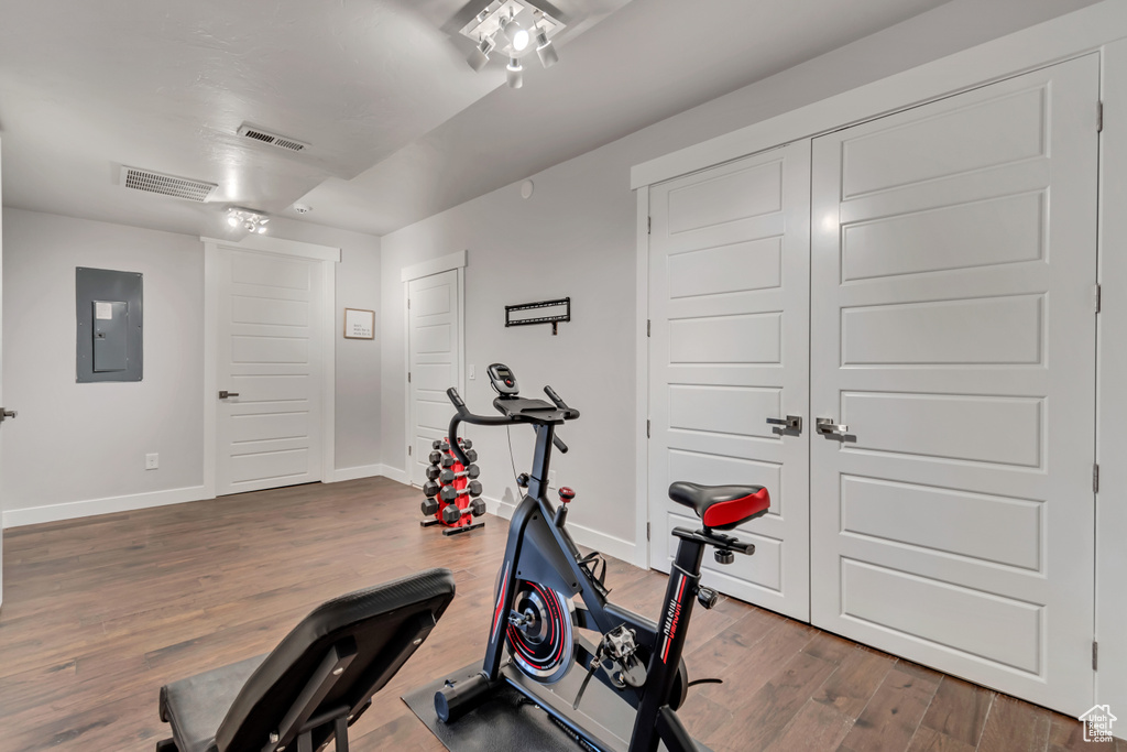 Workout room featuring electric panel and hardwood / wood-style floors