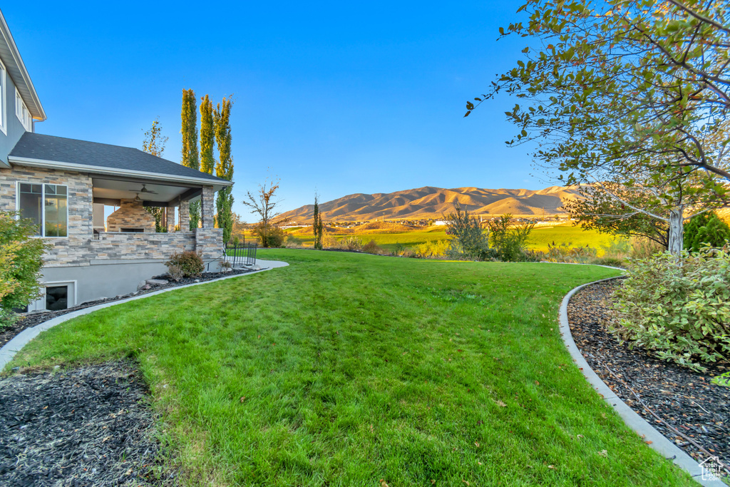 View of yard featuring ceiling fan and a mountain view