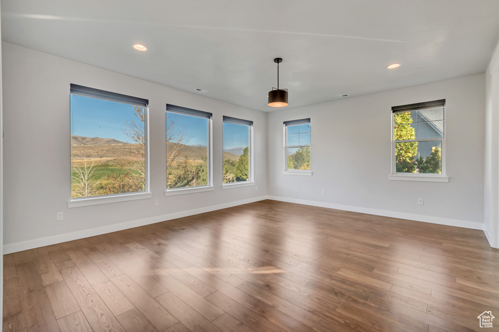 Unfurnished room featuring dark wood-type flooring and a mountain view