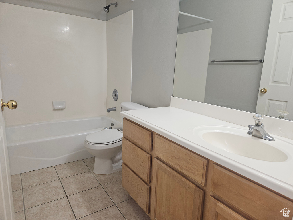 Full bathroom featuring washtub / shower combination, vanity, toilet, and tile patterned floors