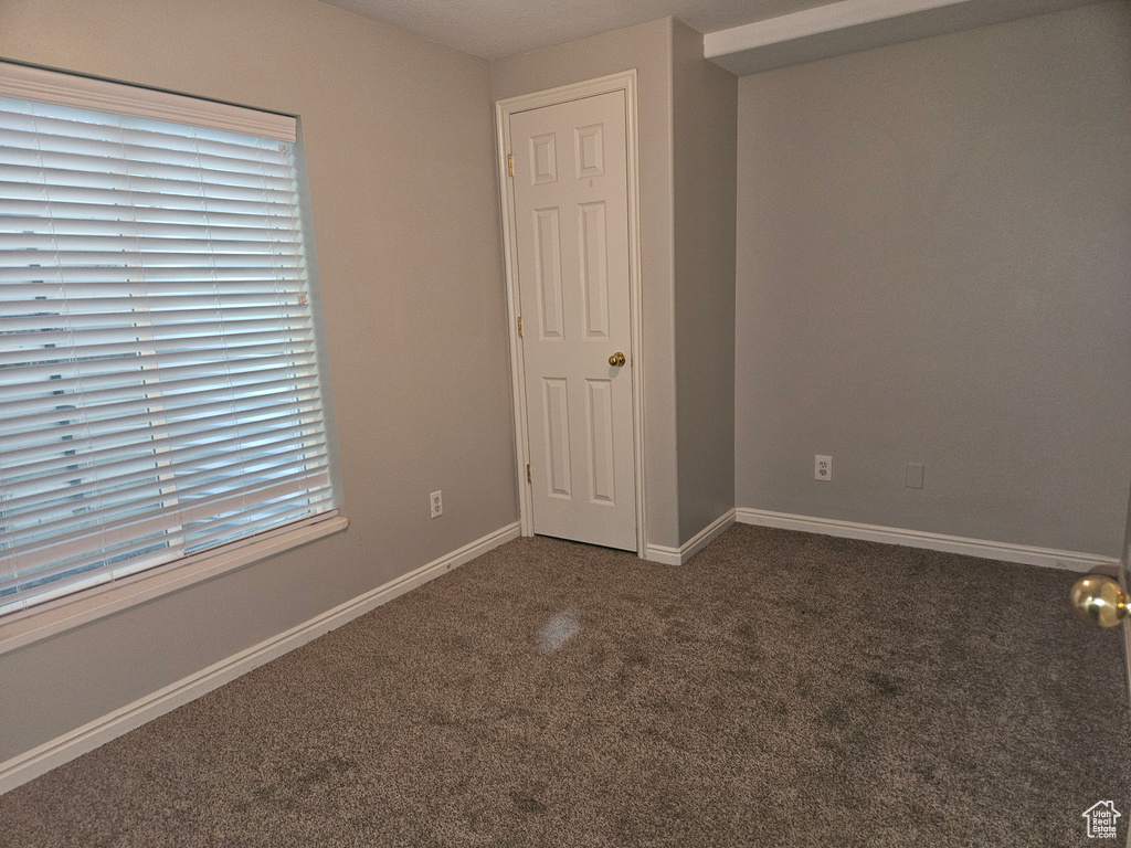 Unfurnished room with dark colored carpet