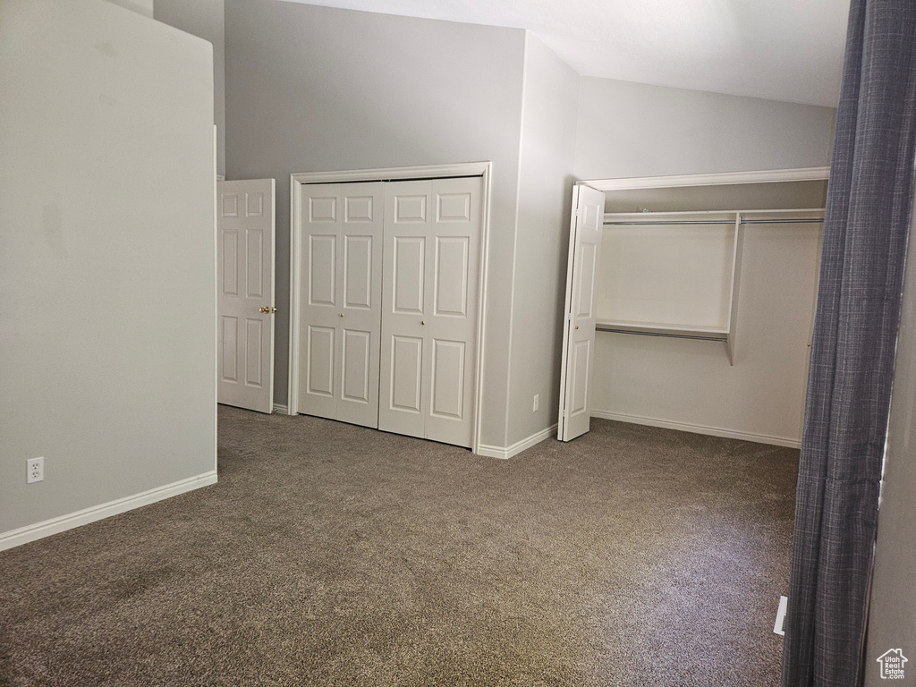 Unfurnished bedroom featuring carpet floors and vaulted ceiling