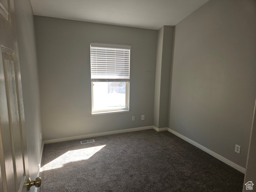 Unfurnished room with dark colored carpet