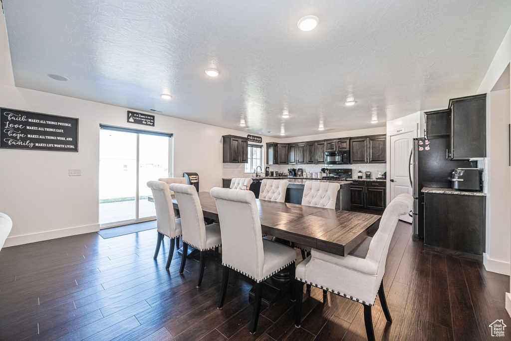 Dining space with a textured ceiling and dark hardwood / wood-style floors