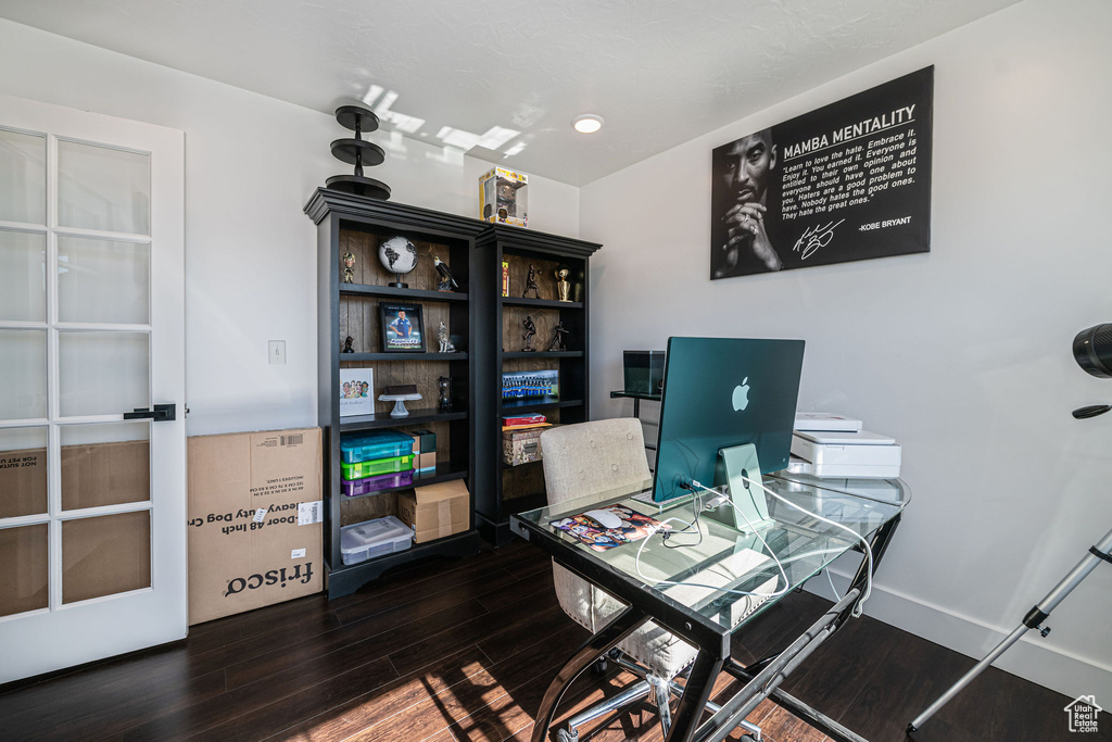 Office space with dark hardwood / wood-style flooring