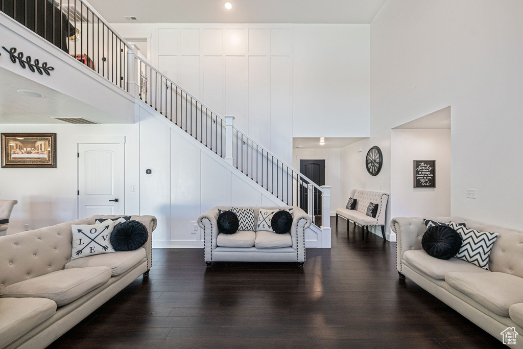 Living room featuring a towering ceiling and dark hardwood / wood-style floors