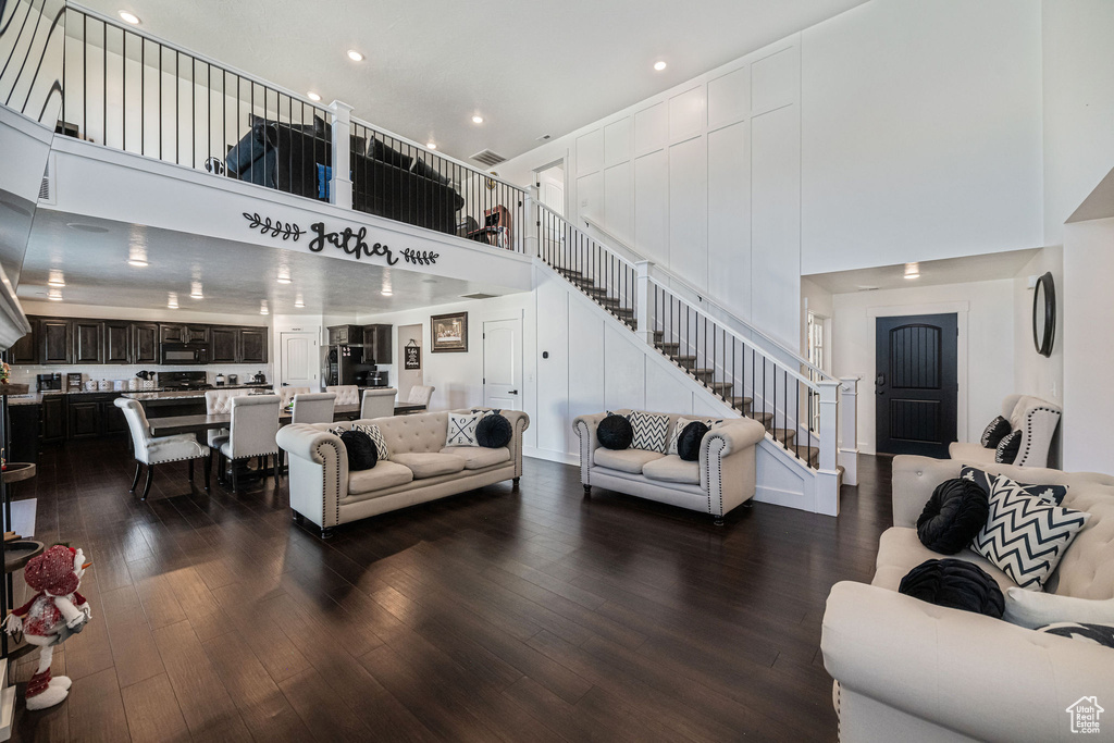 Living room featuring wood-type flooring and a towering ceiling