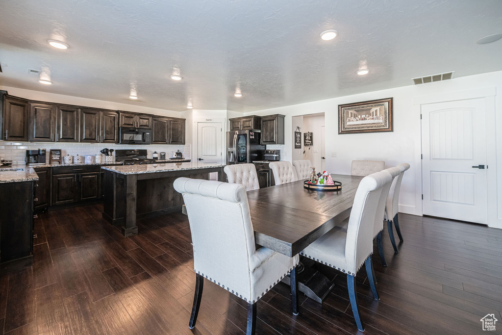 Dining area featuring a textured ceiling and dark hardwood / wood-style floors