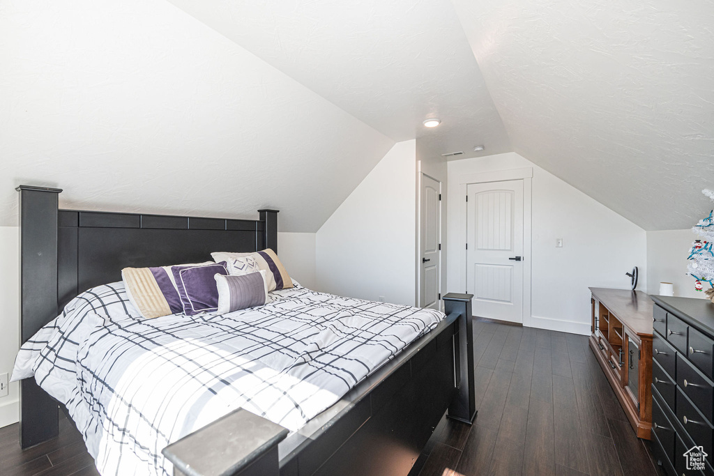 Bedroom with lofted ceiling and dark hardwood / wood-style flooring