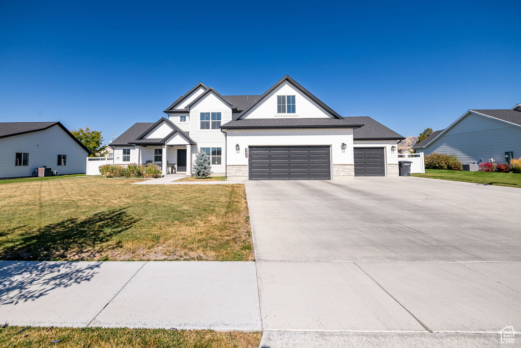 View of front facade featuring a front lawn and a garage