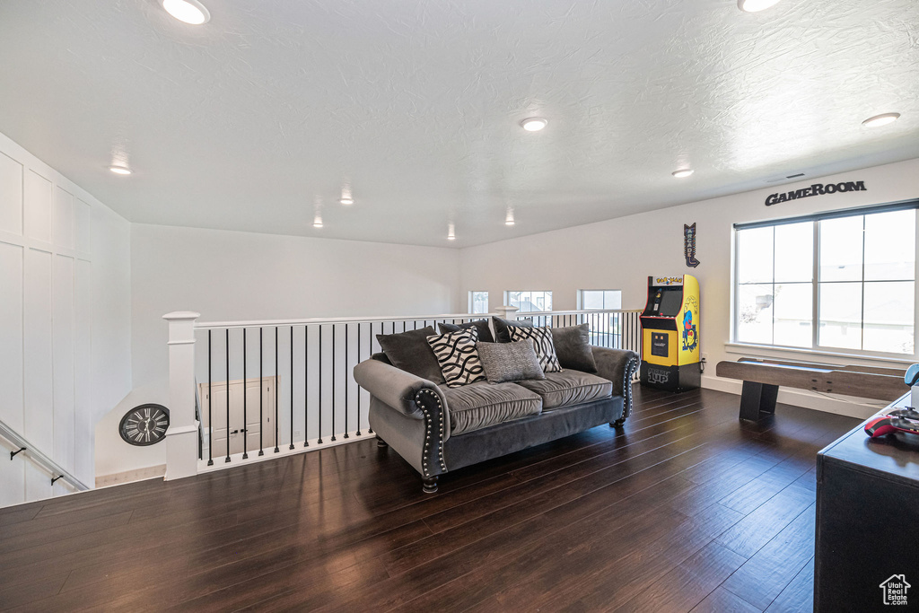 Living room with a textured ceiling and dark wood-type flooring