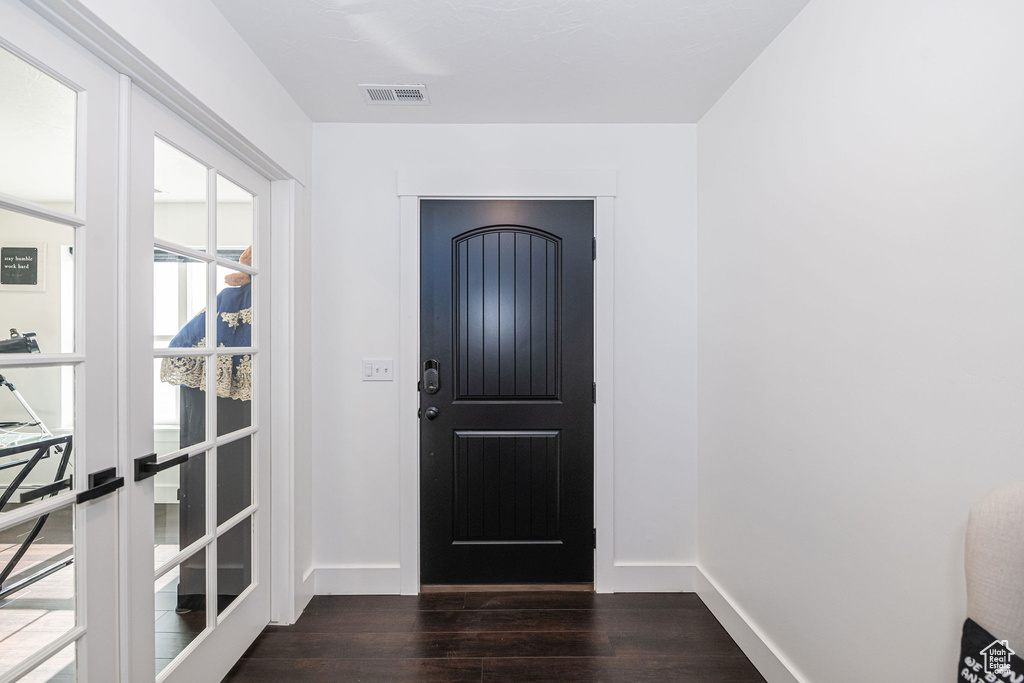 Doorway to outside with dark hardwood / wood-style floors