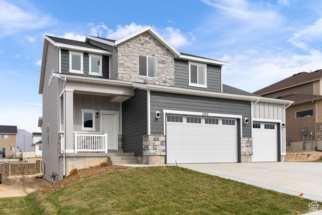 View of front of home with a front lawn and a garage