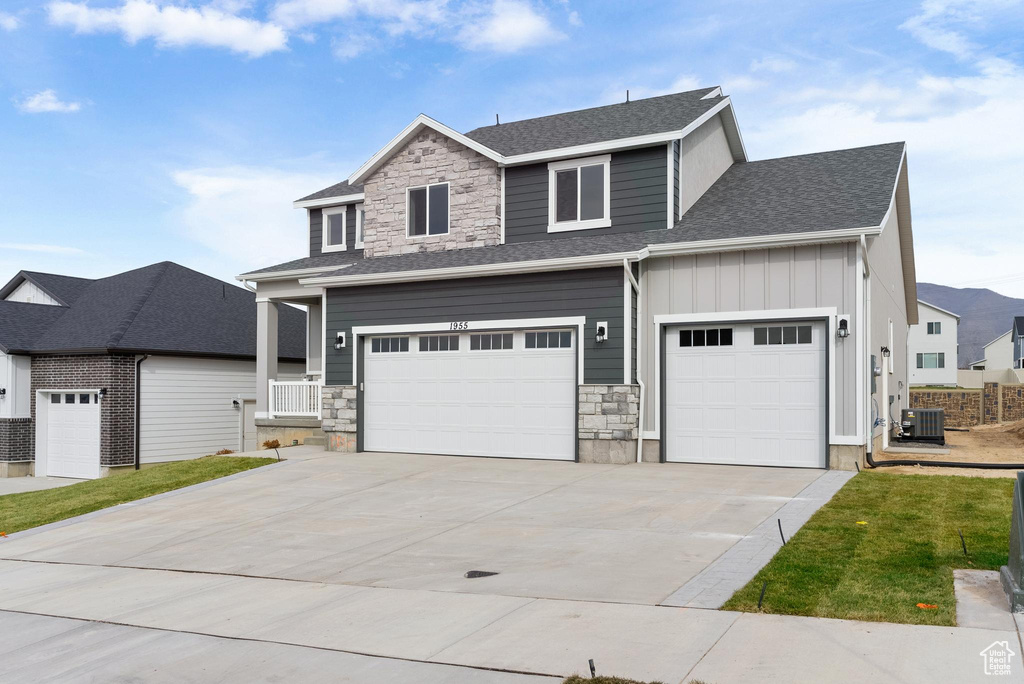 View of front of house featuring cooling unit and a garage