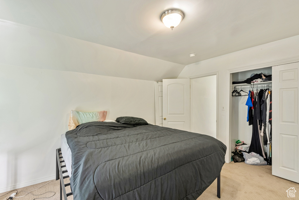 Carpeted bedroom featuring lofted ceiling